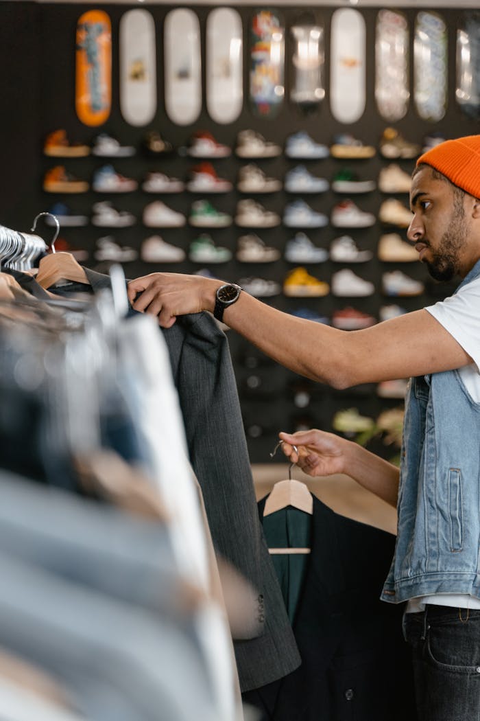 vision Man shopping for jackets in a trendy fashion store with skateboard decor.