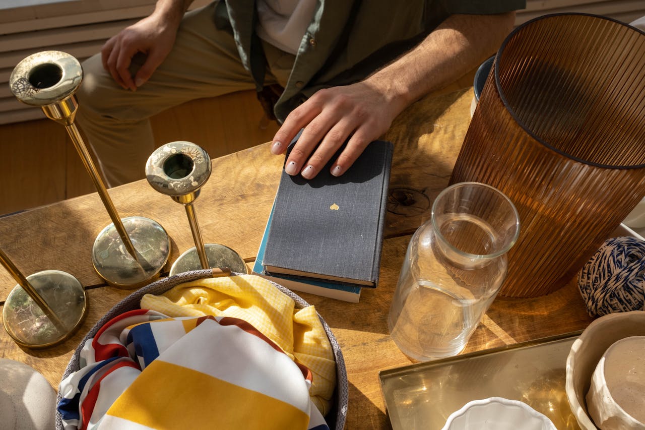 Overhead view of a wooden table with books, candlesticks, and a colorful fabric for a cozy aesthetic.